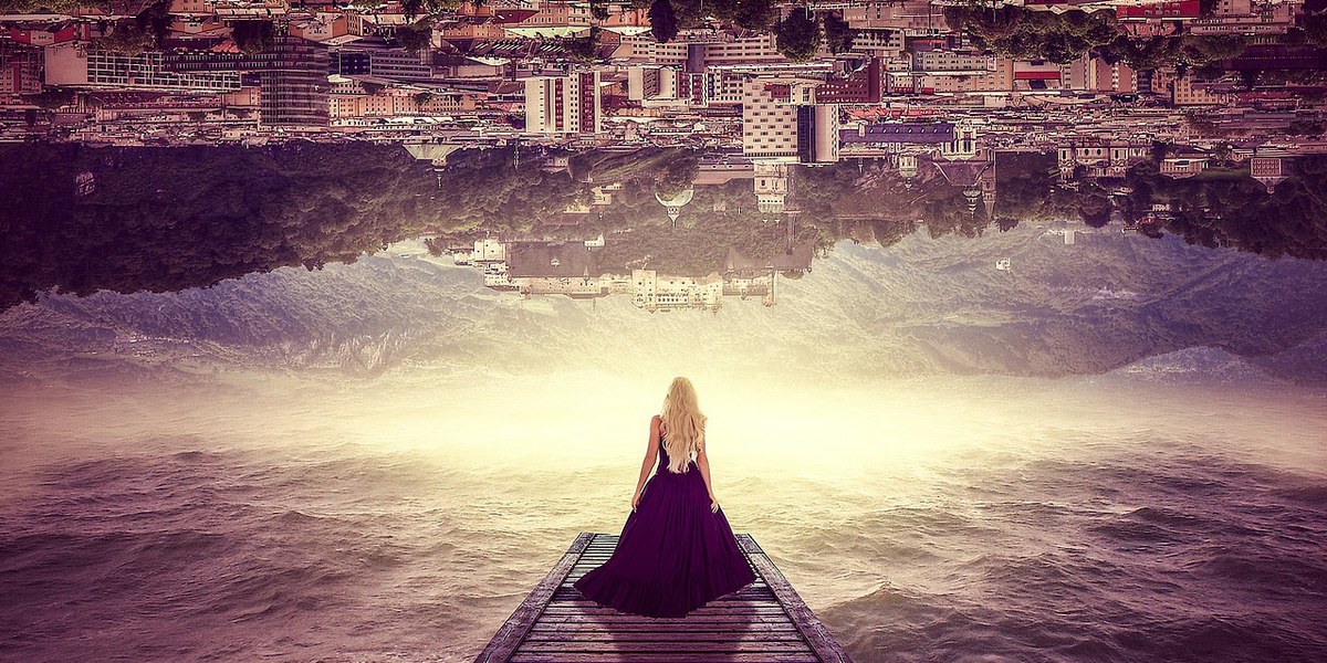 femme sur un pont regardant une ville à l'envers