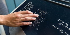 Doigts sur caractères braille